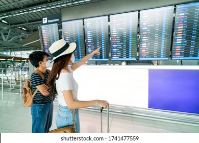 Asian female traveler looking on  flights information board in airport and it show flights cancellation status on because coronavirus or covid-19 pandemic effected. airline business crisis concept