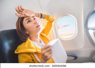 An Asian Female Traveler Suffers From An Acute Attack Of Nausea During Turbulence On A Plane. The Woman Was Seasick And Airsock During Air Flight