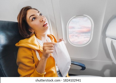 An Asian Female Traveler Suffers From An Acute Attack Of Nausea During Turbulence On A Plane. The Woman Was Seasick And Airsock During Air Flight