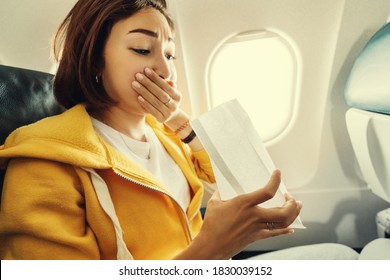 An Asian Female Traveler Suffers From An Acute Attack Of Nausea During Turbulence On A Plane. The Woman Was Seasick And Airsock During Air Flight