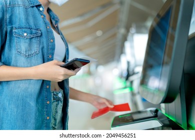asian female traveller casual cloth hand show smartphone scan online check in for flight boarding departure at airport terminal,travel after covid lockdown is over concept