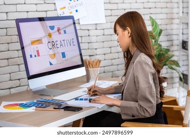 Asian female woman female graphic designer working on creative project with computer and color swatches in modern office - Powered by Shutterstock