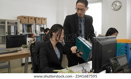 asian female worker refusing to do more work for her manager. she looks at watch and says she doesn’t have enough time to meet the deadline.