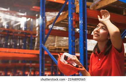 Asian Female Workers Sit And Take Off Their Safety Hats Tired Of The Warehouse Work Many Check Stocks Are Overworked Tired And Exhausted Sit And Take Break To Wipe The Sweat On Their Faces.
