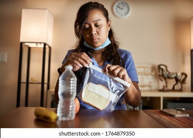 Asian Filipina Nurse At Home Packing Lunch For Work