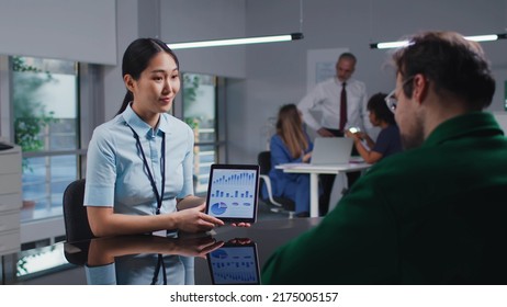 Asian Financial Advisor With Digital Tablet Discuss Investment Strategy With Customer. Male Entrepreneur Consult Financial Specialist In Bank