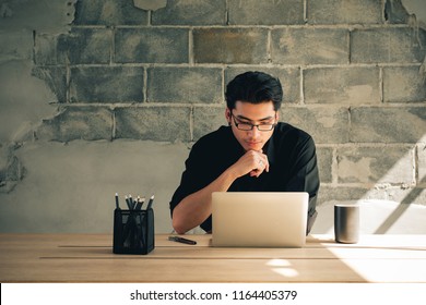 Asian Financial Man Market Analyst Working At Home Office, Businessman Using Laptop, Graphs And Diagram On Notebook Screen.