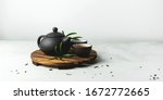 Asian food background with a tea set, cups, and teapot with free space for text on white stone background.