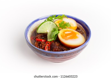 Asian food, Pork and eggs in sweet brown sauce, pork and eggs stewed in the gravy with thai spicy sauce on white background - Shutterstock ID 1126603223