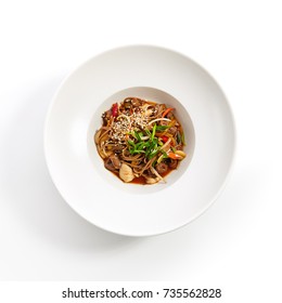 Asian Food Restaurant. Buckwheat Noodles With Chicken Vegetables Sprinkled With Fresh Herbs And Sesame Seeds In White Plate. Top View