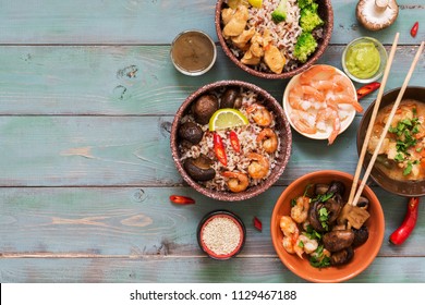 Asian Food - Rice With Prawns, Chicken, Mushrooms, Broccoli On A Naked Rustic Background. Concept Of Asian Food. Flat Lay Of The Copy Space