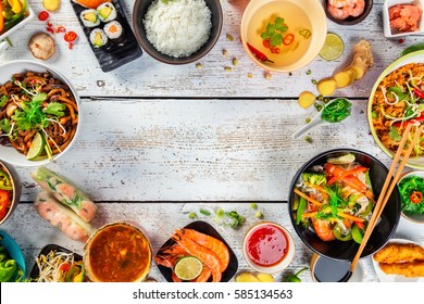 Asian food served on white wooden table, top view, space for text. Chinese and vietnamese cuisine set.