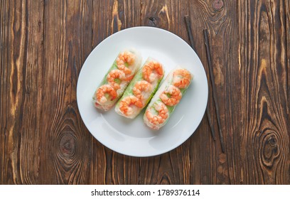 Asian Food Spring Rolls With Shrimps On A Dark Wooden Background. Spring Rolls In Rice Paper With A Chopsticks. Top View Space For Text