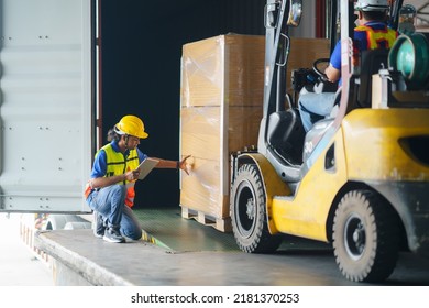 Asian forklift driver loading a shipping cargo container with a full pallet with boxes in logistics port terminal. Asian warehouse worker and safety inspector with digital tablet manage the process. - Powered by Shutterstock