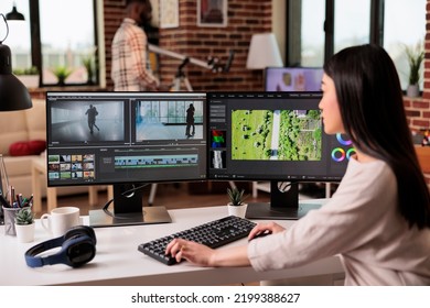 Asian Freelancer Editing Audio Film Montage With Post Production Software On Computer. Videographer Working On Movie Footage Edit With Color Grading And Visual Or Sound Effects At Home.