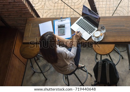 Asian freelancer working on laptop at cafe
