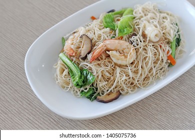 asian fried noodle with shrimp and vegetable on white dish