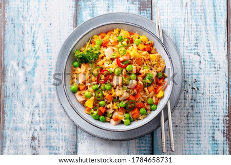 Asian fried rice with ham. Blue wooden background. Close up. Top view.