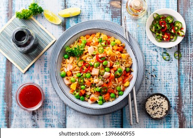 Asian fried rice with pork ham.  Blue wooden background. Top view.