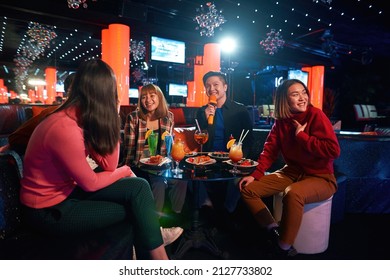 Asian Friends Having Fun While Singing Karaoke On Night Party At The Bar, Enjoying Friendship Together In Bar, Concept Of Party, Holiday, Group Of Happy Friends Having Fun, Singing In Karaoke Club,