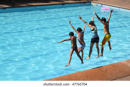 Asian Friends Jumping On The Swimming Pool