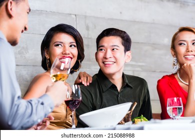 Asian Friends, Two Couples, Dining In Fancy Restaurant Eating Good Food And Drinking Wine