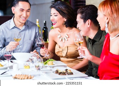 Asian Friends, Two Couples, Dining In Fancy Restaurant Eating Good Food And Drinking Wine