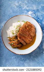 Asian fusion vegan meat-free chickpea steak, garnished with carrot, zucchini and soft white rice