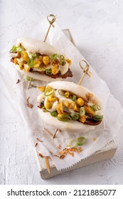 Asian fusion vegan white soft bao buns with meat alternative, mayo and crunchy spicy peanuts