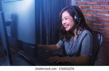 Asian Gamer Girl Woman Nerdy Geek Casual Playing Video Games Computer Cheering Winning Having Fun Excited At Home Computer Desk Setup Technology Wearing Headset Voice Chat Team Play Online Cyberspace