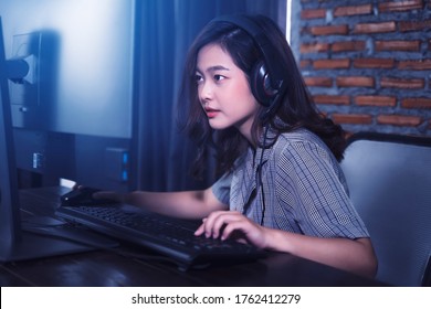 Asian Gamer Girl Woman Nerdy Geek Casual Playing Video Games Computer Cheering Winning Having Fun Excited At Home Computer Desk Setup Technology Wearing Headset Voice Chat Team Play Online Cyberspace