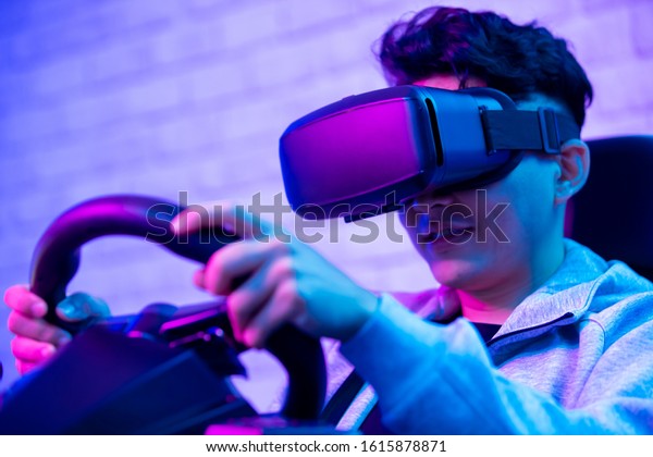 asian
gamer play car racing game with wearing vr glasses
