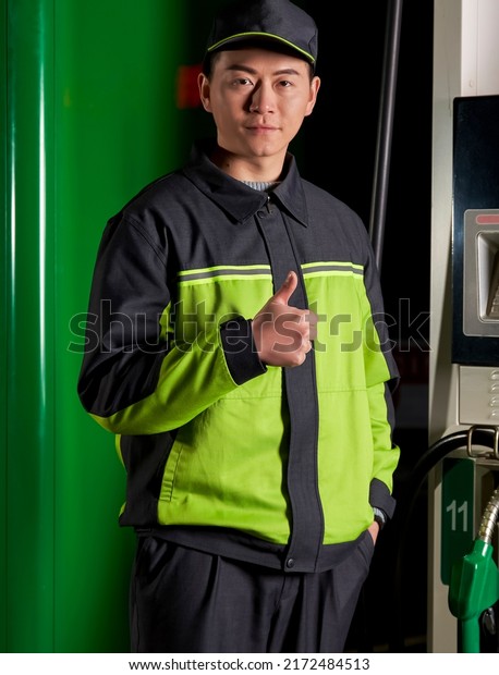 Asian gas station\
worker showing thumbs up