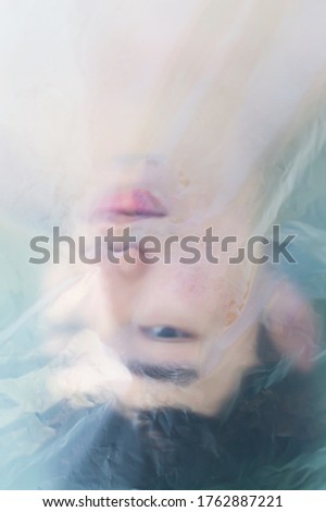 Similar – Woman face lying down over hands with colorful sparkles in skin