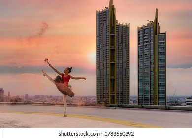 Asian Gilr Street Ballet Dancer Having Ballet Dance Performance On Rooftop Of Skyscraper In City With Background Of Suntset Sky