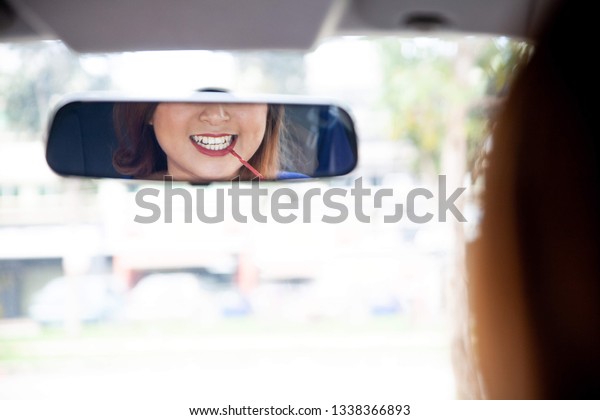 asian girl applying make
up in the car