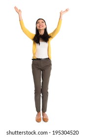 Asian girl arms up, looking upwards like holding something above, full length standing isolated on white background.