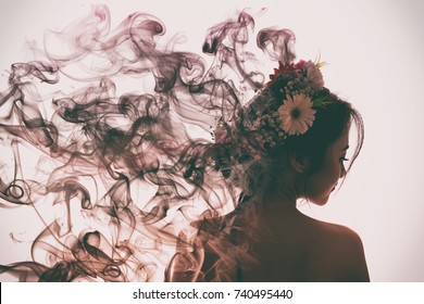 Menina asiática é bonita e encantadora com flores coroa. Ela está evaporando em fumaça de perfume. Estilo vintage.