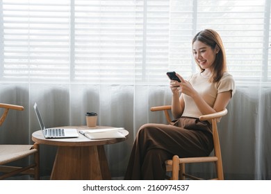 Asian girl. Beautiful woman enjoys talking on the phone in the house by the window. - Powered by Shutterstock