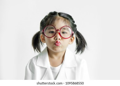 Asian Girl With Big Glass And Science Suite Action On White Screen. Kiss Action Kid Model With Doctor Or Science Costume.