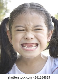 Asian Girl Child With Funny Big Smile Showing Front Tooth Dental Loss