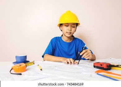 Asian Girl Child Playing As An Engineer The Building Layout And Helmet Are Smiling And Happy On Weekends.