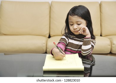 Asian Girl Child Writing On The Living Room