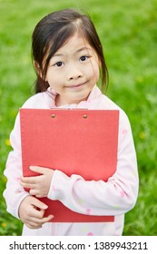 Asian Girl With Clipboard At The Scavenger Hunt On A Kids Birthday