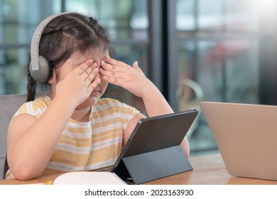 Asian girl covered her eyes from digital eye strain, girl used tablets too much to cause eye strain,eyes problems from using a tablet,education and vision problems. - Shutterstock ID 2023163930