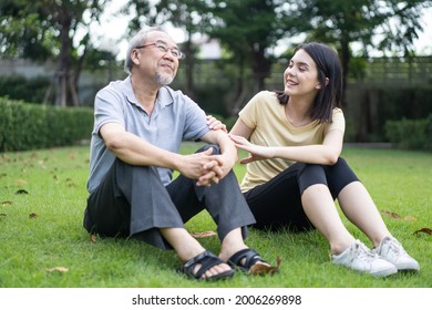 Asian Girl Daughter Take Care Of Senior Elderly Grandfather In Garden. Attractive Young Beautiful Woman And Older Mature Man Father Enjoy Talking And Have Fun Outdoor At Backyard During Summer Time.