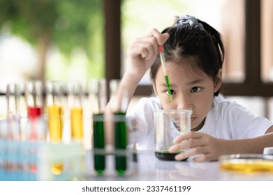 Asian girl doing science experiment with doubt, Schoolboy's test tube chemical experiment, schoolgirl doubting in science, science experiment concept. - Powered by Shutterstock