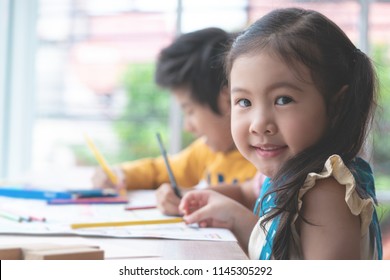 Asian Girl Is Drawing In Kindergarten Art Classroom