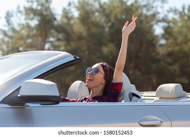 Asian Girl Driving Cabriolet And Holding Hand Up