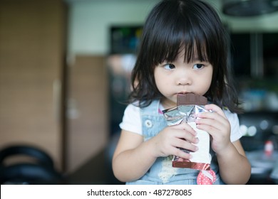 Asian Girl Eating Chocolate In Home.Two Years.